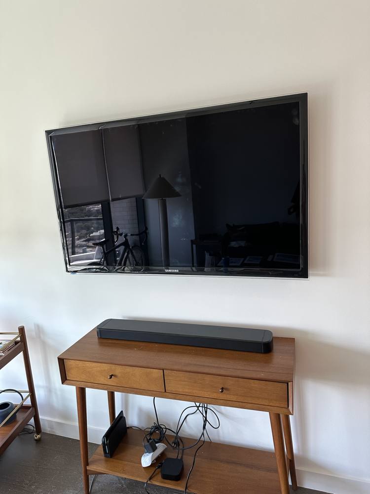 Samsung TV mounted above a mid-century console